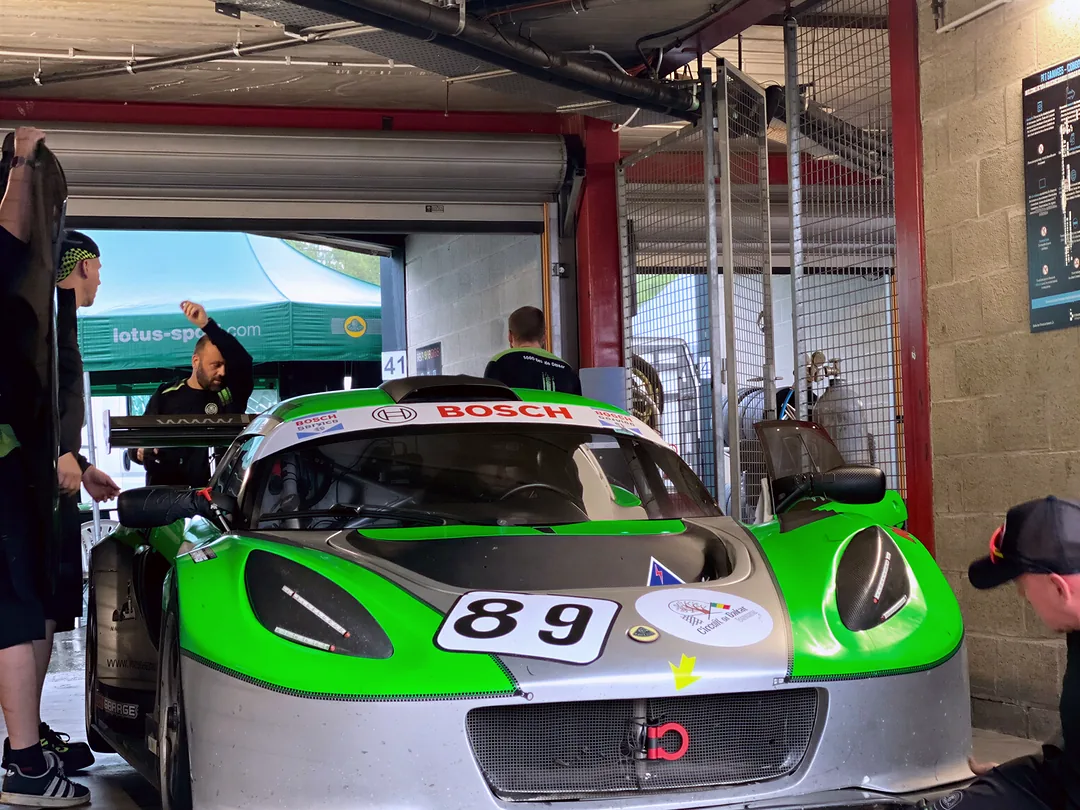 Zelený Exige 89 v boxech ve Spa, mechanik pod vozem