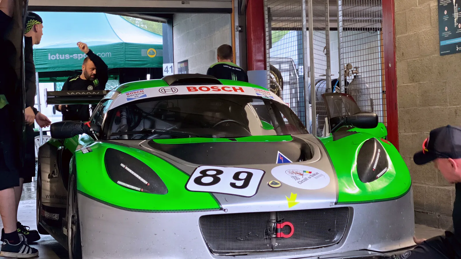 Zelený Exige 89 v boxech ve Spa, mechanik pod vozem