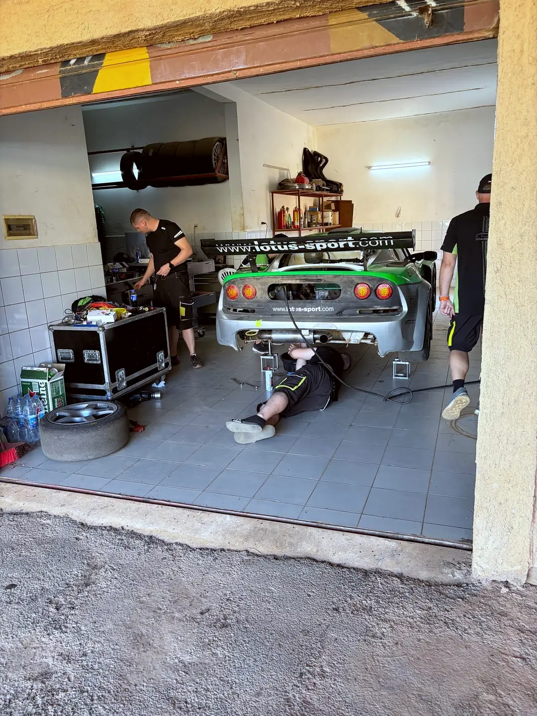 Garáž, mechanik pod vozem 88, sedící zboku, Circuit de Baobab