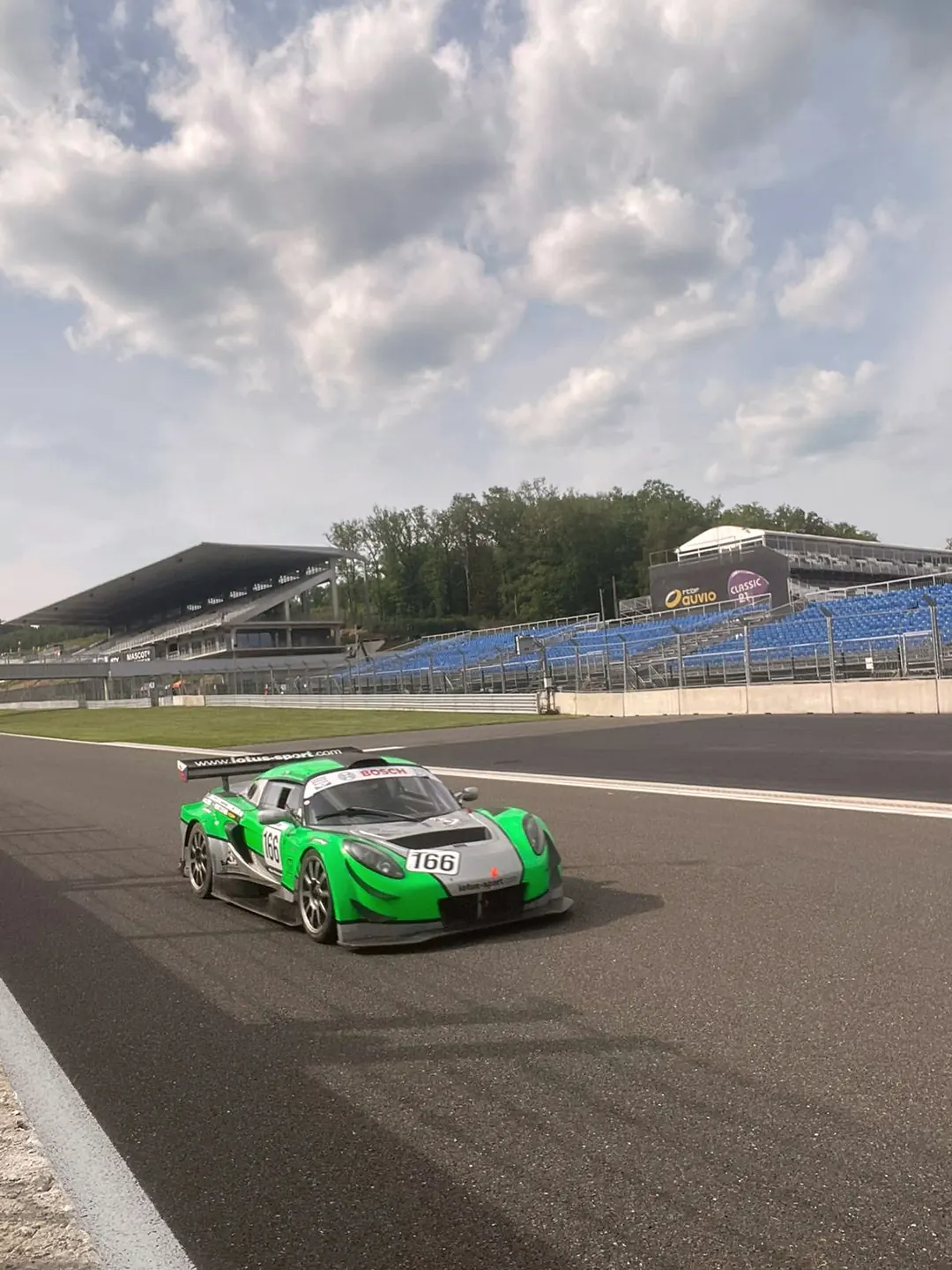 Zelený Exige 166 na trati u tribuny, Spa-Francorchamps