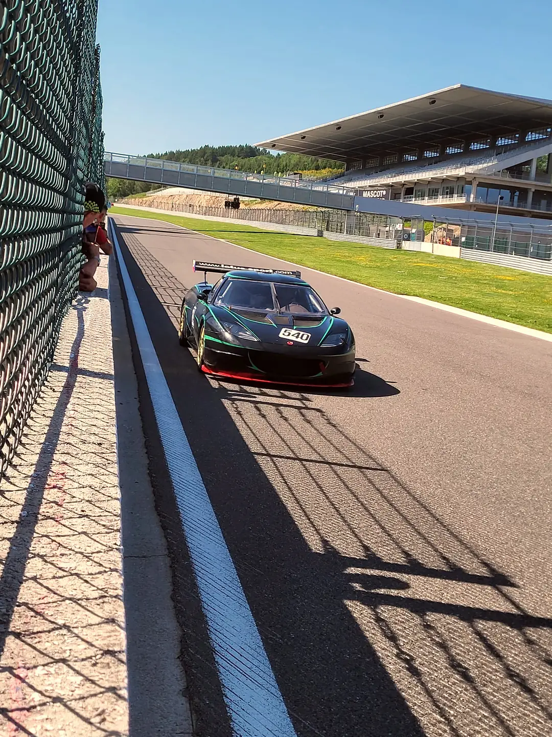 Evora v pit lane zdálky, tribuna Spa v pozadí, Spa-Francorchamps