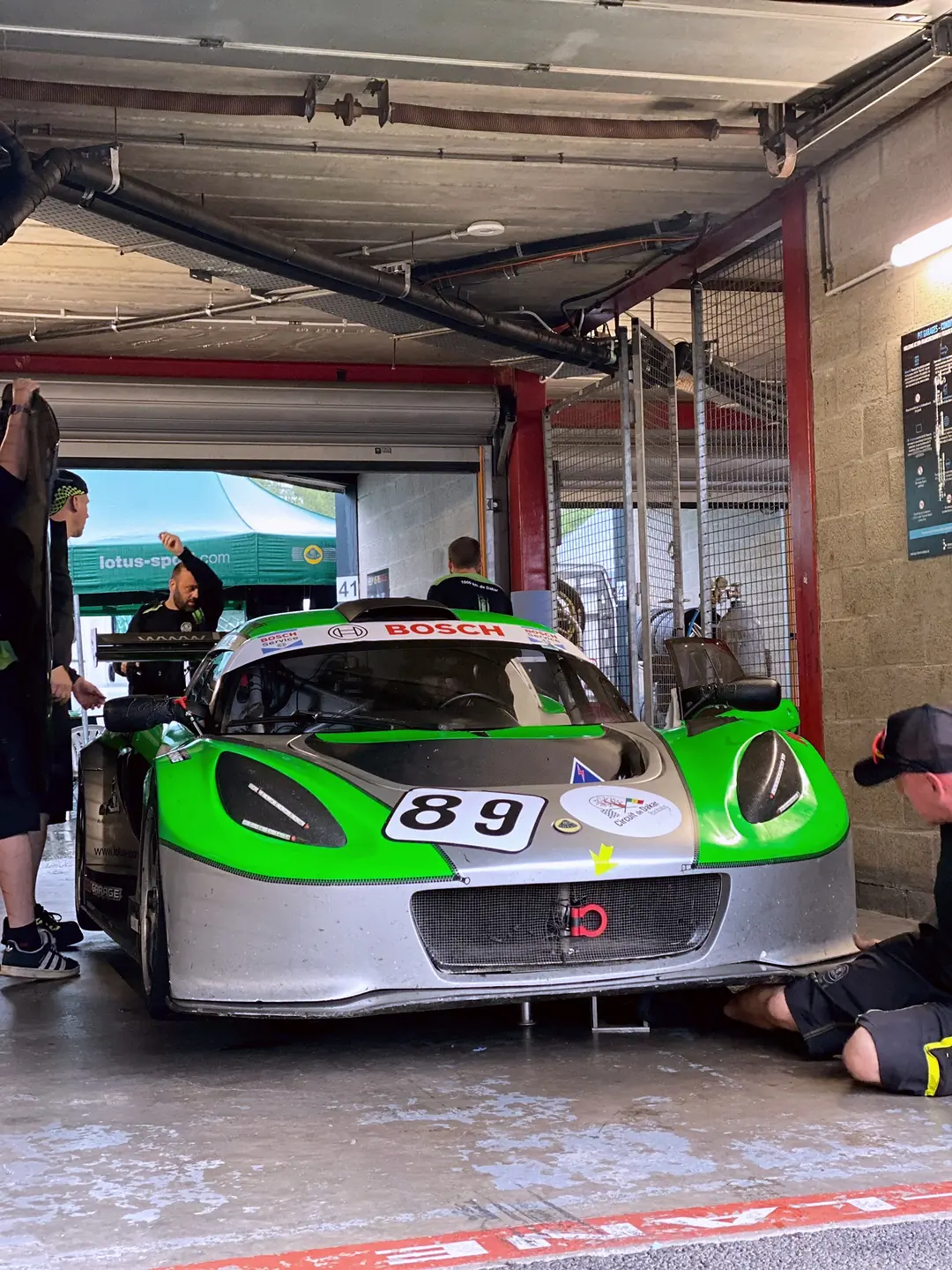 Exige 89 zeleno-stříbrný v boxu, mechanik, Spa-Francorchamps