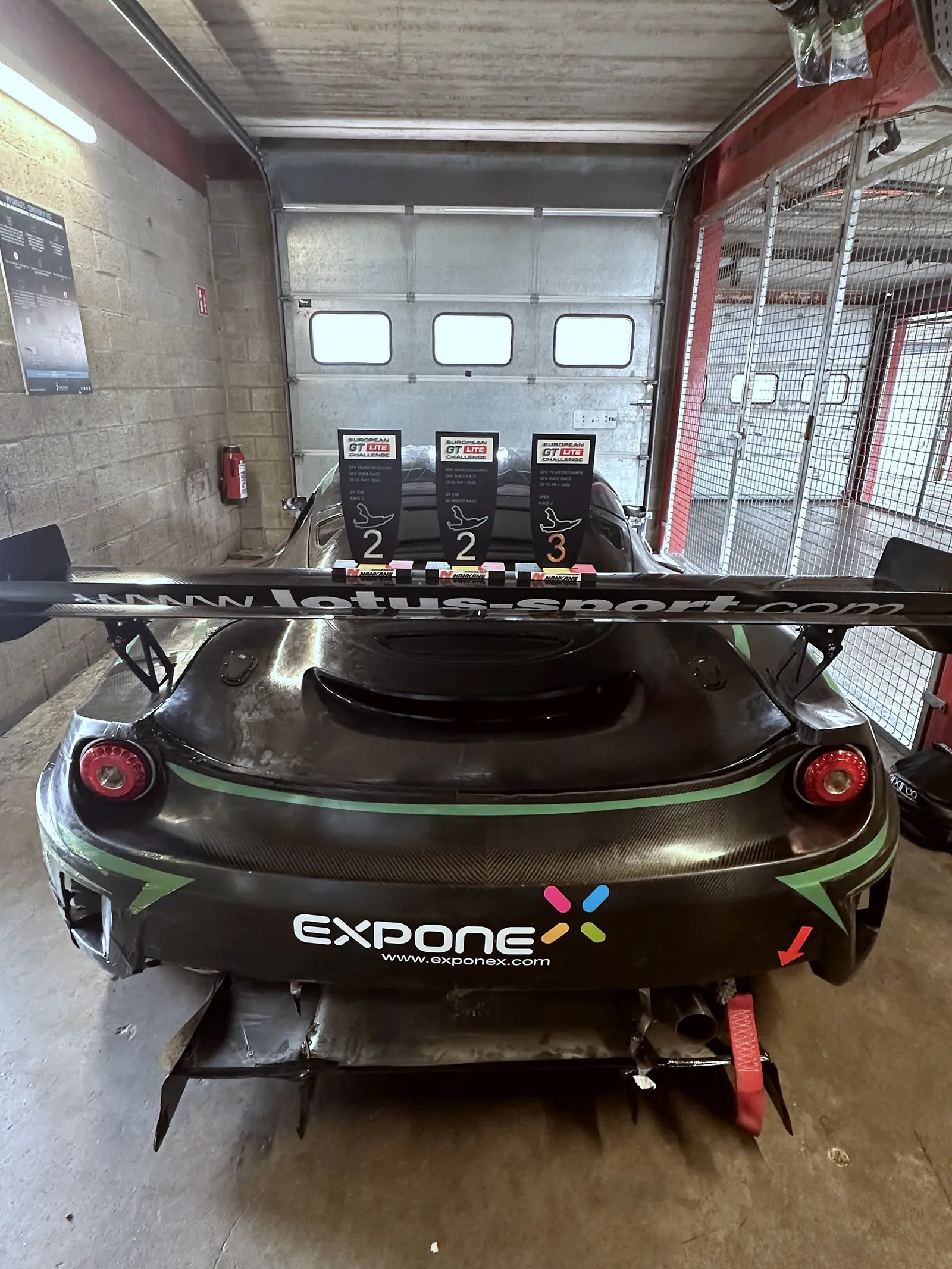 Černá Evora zezadu v boxu, křídlo, difuzor, Spa-Francorchamps