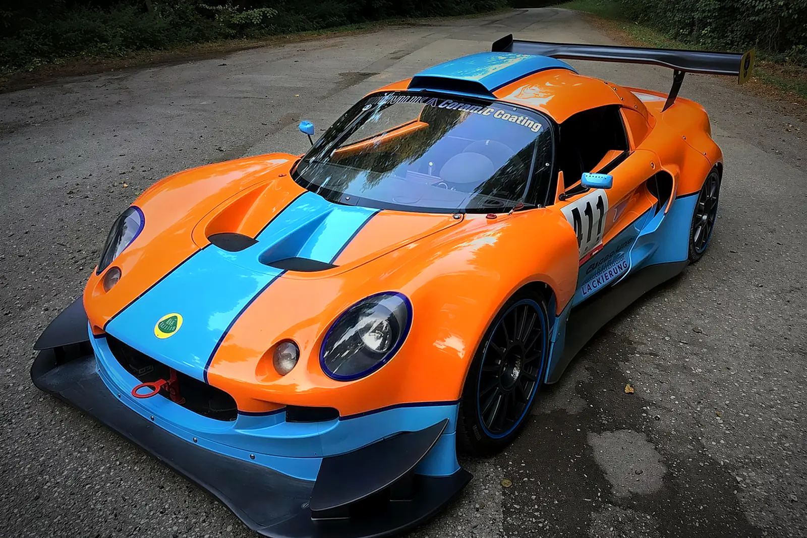 Lotus Exige v modrooranžovém laku Gulf s číslem 111, zepředu z boku