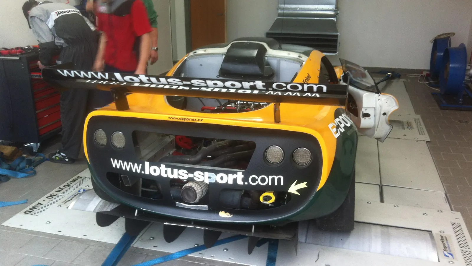 Exige zezadu na válcové brzdě, mechanici u vozu